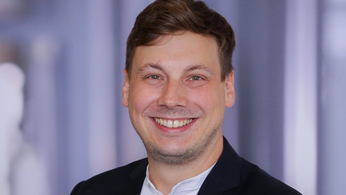 Dennis Bischoff lächelt in die Kamera.
