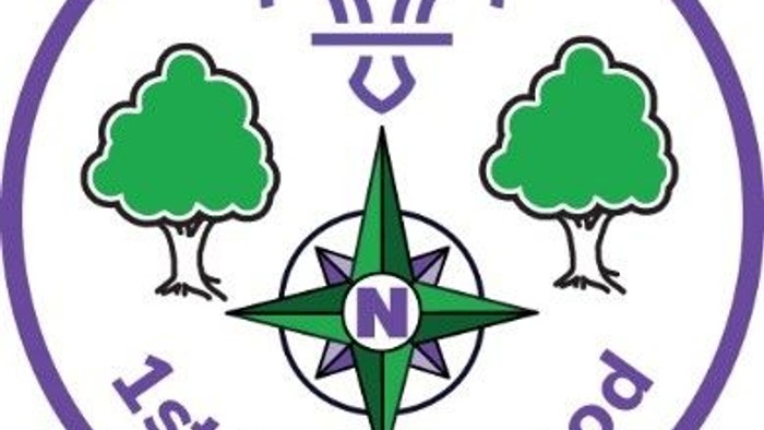 Scouting emblem for 1st Northwood featuring trees, compass, and fleur-de-lis symbol.