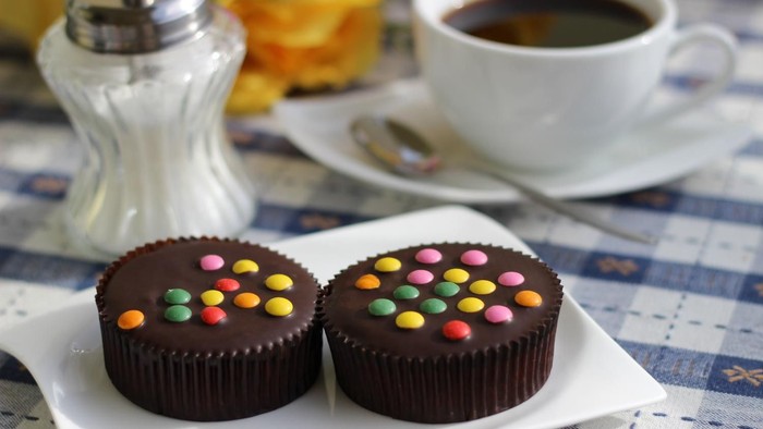 Bild von einer Kaffeetasse und zwei Muffins mit Schokolinsen