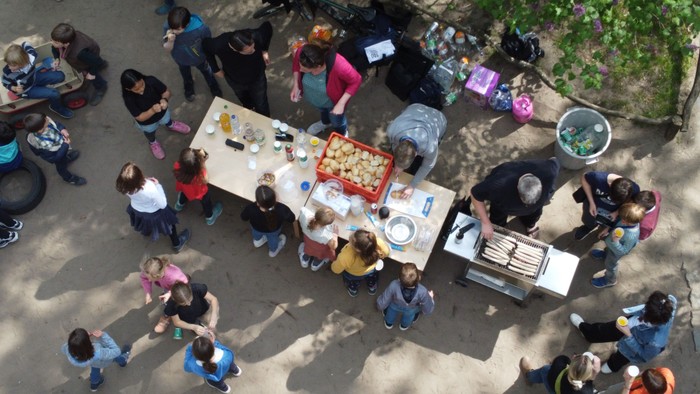 Ein lebhaftes Treffen im Freien, bei dem Menschen bei einer Gemeinschaftsveranstaltung Essen servieren und genießen.