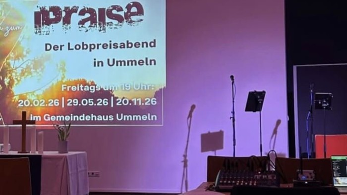 Veranstaltungsaufbau für ein Lobpreiskonzert in Ummeln mit Bühne, Stühlen und Werbedisplay für den „Lobpreisabend“.