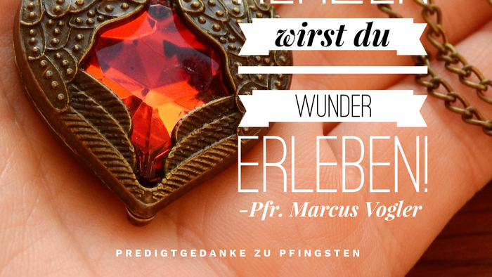 Ein herzförmiges Anhänger mit einem roten Edelstein und inspirierendem deutschen Text über das Erleben von Wundern mit dem Heiligen Geist.