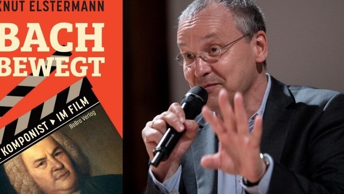 Ein Mann spricht bei einer Veranstaltung über das Buch *„Bach bewegt“* und diskutiert den Komponisten Johann Sebastian Bach.