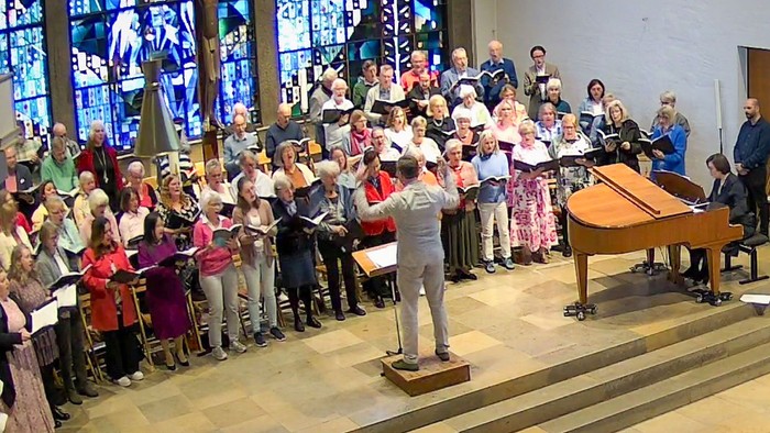 Ein bunt gemischter Chor singt in einem modernen Altarraum