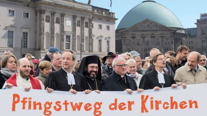Ein Gruppe von Menschen hält ein Banner mit der Aufschrift