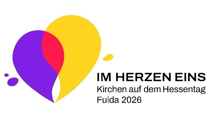 Logo der Kirchen auf dem Hessentag Fulda 2026 mit stilisiertem Herz aus überlappenden gelben, violetten und pinken Flächen. Rechts daneben steht der Schriftzug „IM HERZEN EINS – Kirchen auf dem Hessentag Fulda 2026“. Minimalistisches, modernes Grafikdesig