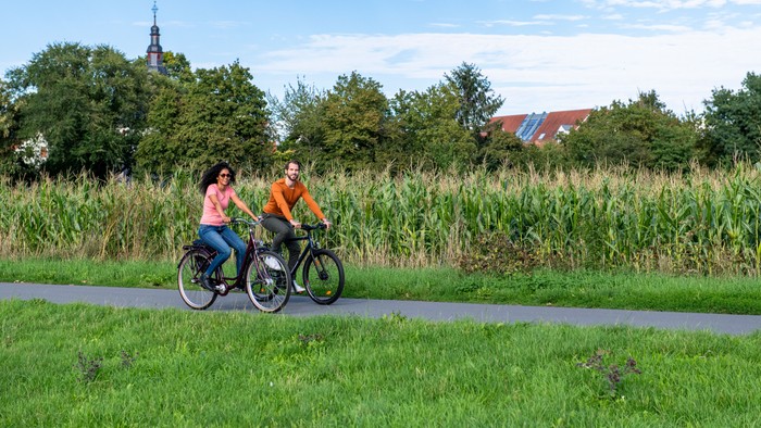 Junge Menschen fahren Fahrrad. Im Hintergrund ist ein Kirchturm zu sehen (Foto: Felix Krammer / Stadtradeln)