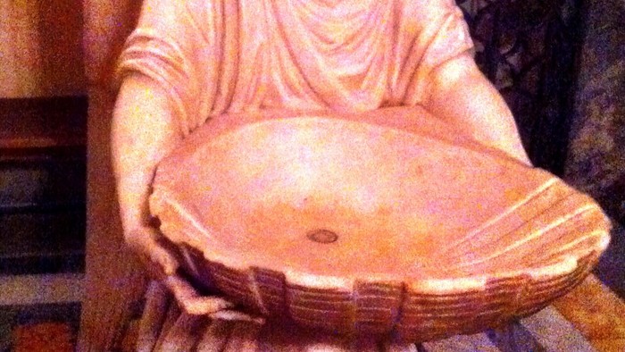 Angel statue holding a bowl.