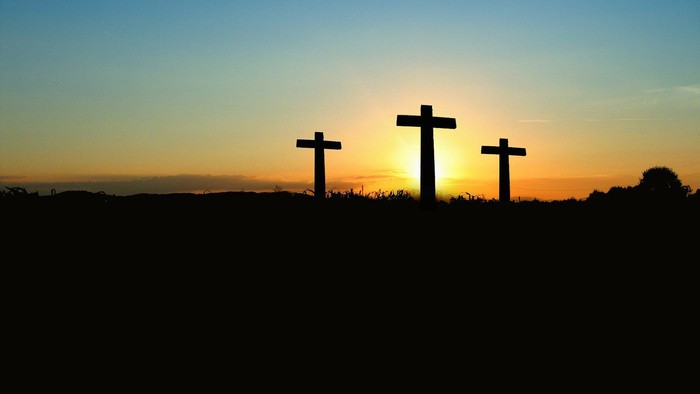 Three crosses against sunset sky