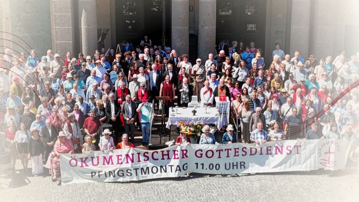 mehrere hundert Menschen, die für Foto posieren, davor Banner