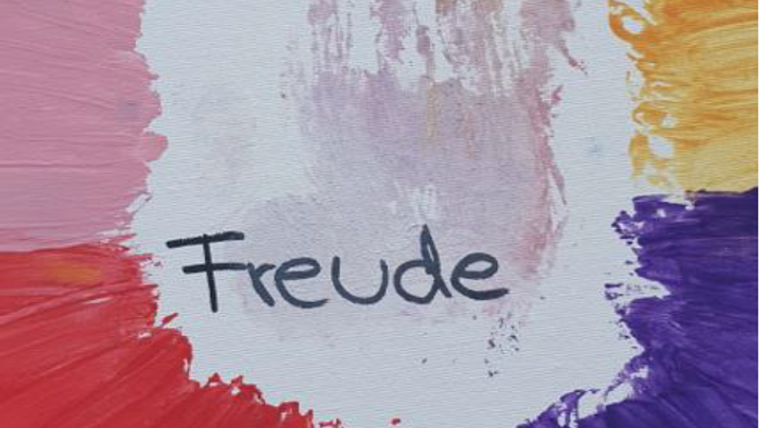 Hand in bunten Farben und das Wort Freude
