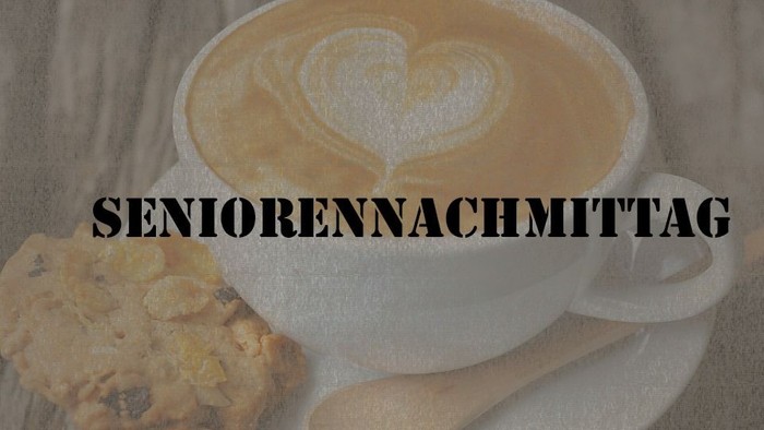 Ein Latte Macchiato mit Herzverzierung und ein Keks auf einem Teller