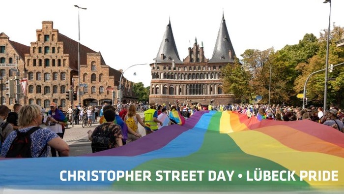 Christopher Street Day in Lübeck: farbige Fahne vor historischem Gebäude