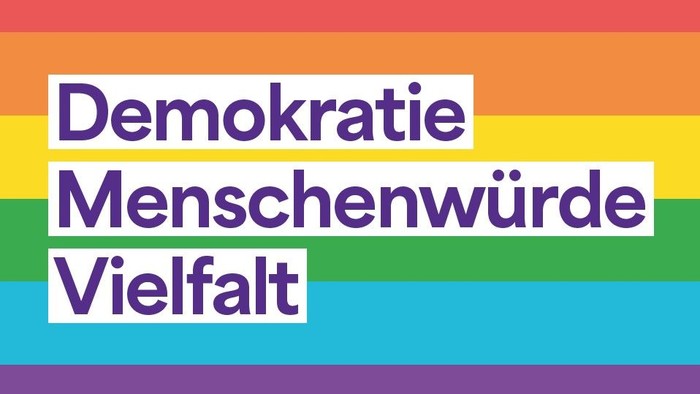 Auf Regenbogenfarben steht: Demokratie, Menschenwürde, Vielfalt