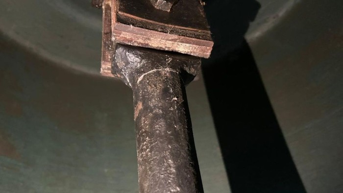 Verrostete Metallrohrverbindung mit sichtbarer Korrosion und Abnutzung in der Nähe einer mechanischen Komponente.