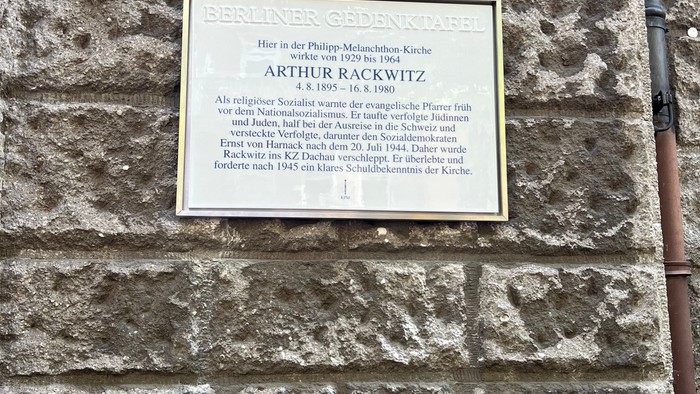 Gedenktafel zu Ehren von Arthur Rackwitz, angebracht an einer Steinmauer mit deutschem Text.