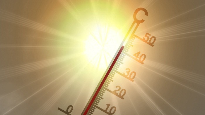 Thermometer zeigt 42 Grad an, dahinter scheinende Sonne