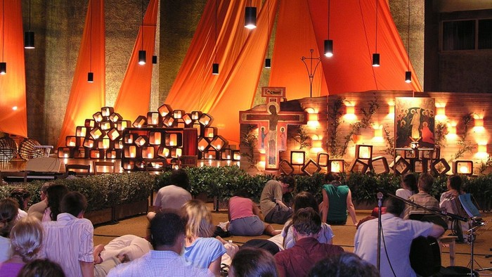 Foto eines Taizegottesdienstes. Eine Reihe junger Menschen sind von hinten zu sehen.