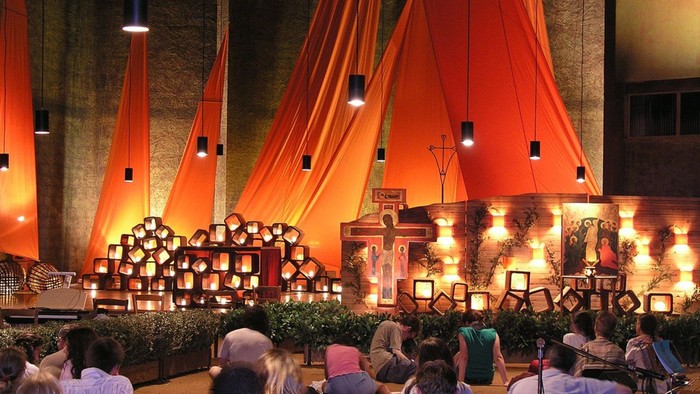 Foto eines Taizegottesdienstes. Eine Reihe junger Menschen sind von hinten zu sehen.
