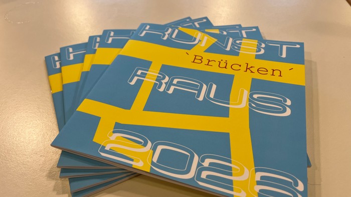 Stapel blauer und gelber Kalender mit der Aufschrift „Brücken' raus“ für das Jahr 2023.