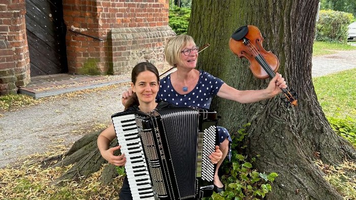 Das Duo ViolAkkord vor einer Kirche.