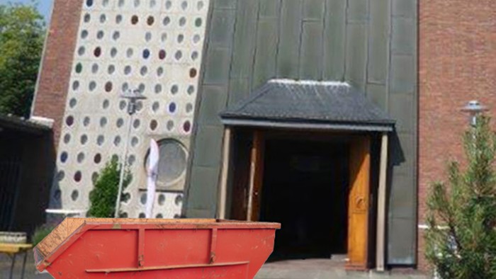 Moderner Gebäudeeingang mit perforierter Fassade, rotem Boot und gelber Tür neben einer Backsteinmauer.