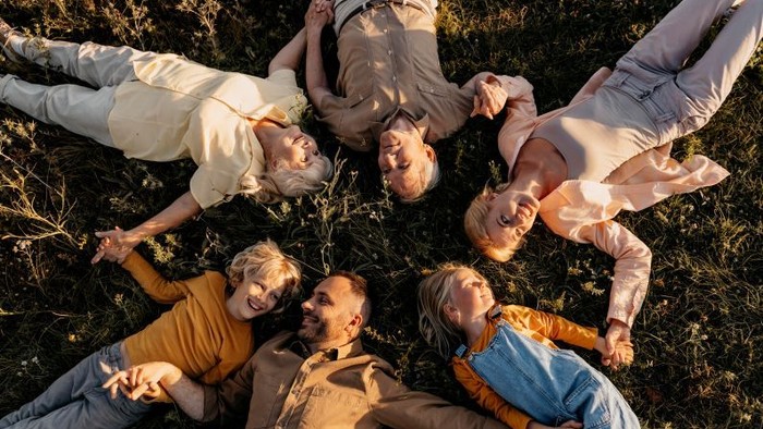 Menschen unterschiedlicher Generation liegen auf Wiese