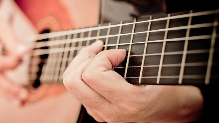 Eine Hand spielt eine Gitarre