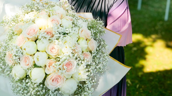 Ein sehr großer Brautstrauß aus cremefarbenen Rosen