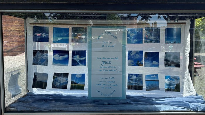 Ein Gedenkdisplay mit gerahmten Himmelsfotos und herzlichen Inschriften an einem Fenster.