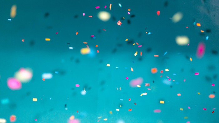 Bunter Glitzerregen vor blauem Hintergrund