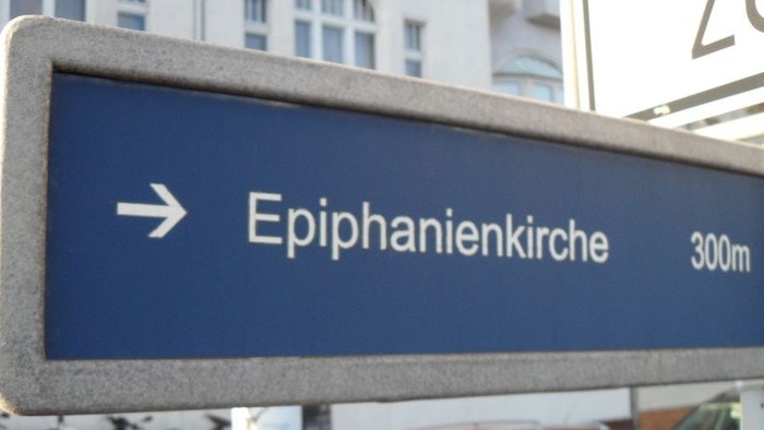 Hinweisschild mit Richtung zur Epiphanienkirche in 300 Metern.