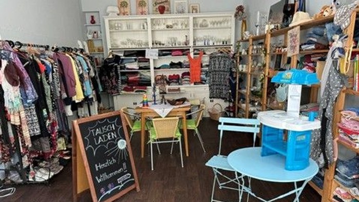 Bezaubernde Kinderboutique mit Kleidung, Spielzeug und einem gemütlichen Spielbereich mit farbenfrohen Möbeln.