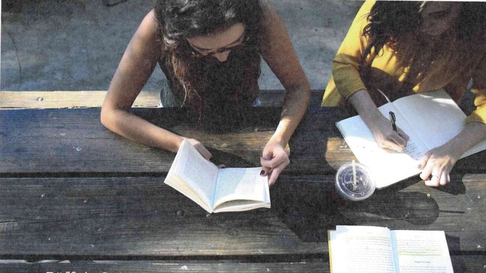 Menschen, die im Freien mit offenen Büchern und Notizen bei einer Veranstaltung „Buffet & Beten“ lernen.