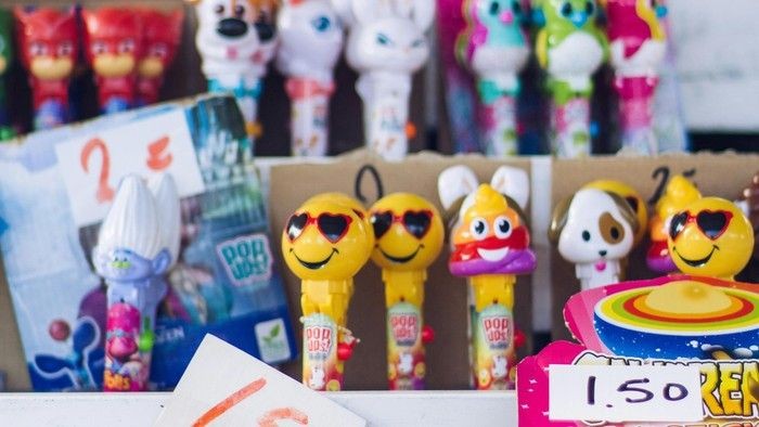 Bunte Schlüsselanhänger und Plüschtiere, arrangiert auf einer Auslage mit Preisschildern und Verpackungen.
