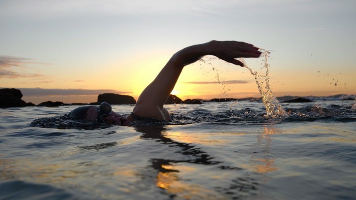 Ein Schwimmer im Meer im Sonnenuntergang