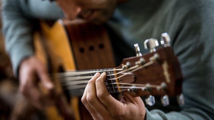 Ein Mann spielt auf einer Gitarre.
