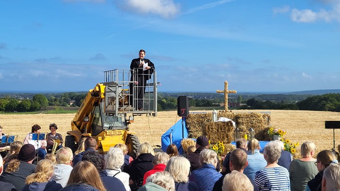 Mann spricht auf Bühne in Feld vor Publikum