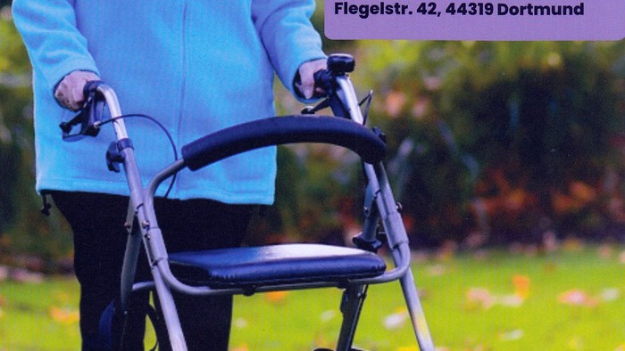 Eine ältere Frau benutzt einen Rollator bei einer Sicherheitsveranstaltung im Freien am 13. August 2026.