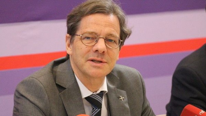 Mann im Anzug spricht in Mikrofon