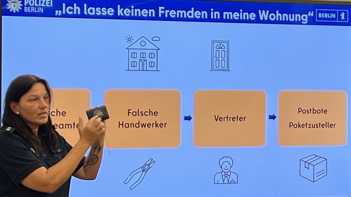 Eine Polizistin in Uniform vor einer Präsentation