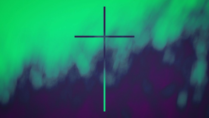 A black cross centered on a blurred, colorful background.