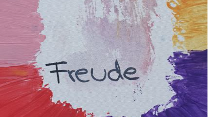 Hand in bunten Farben und das Wort Freude