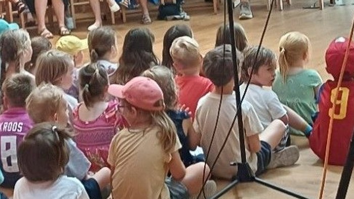 Kinder sitzen in der Kirche auf dem Boden