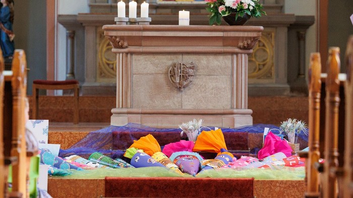 Schultüten liegen vor einem Altar (Motivbild)
