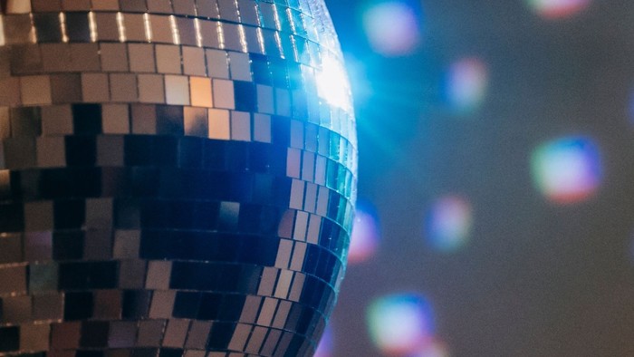 Ein Diskokugel reflektiert bunte Lichter.