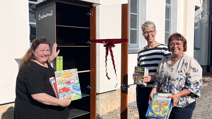 Hier befüllen die drei Organisatorinnen den Bücherschrank mit ersten Kinderbüchern.