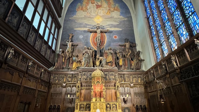 Die Kirche mit hohem Altar und buntem Glasfenster