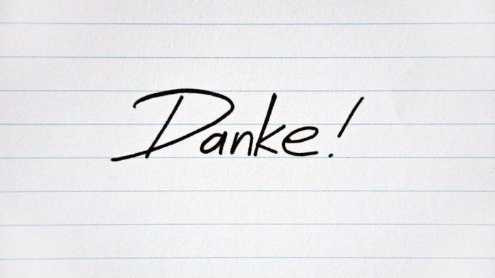 Handschriftliche Notiz mit dem Wort 'Danke!' auf liniertem Papier.