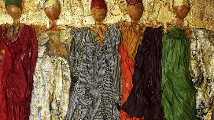 Bunte Kleider mit aufwendigen Mustern und goldene Kopfschmucke zusammen ausgestellt.
